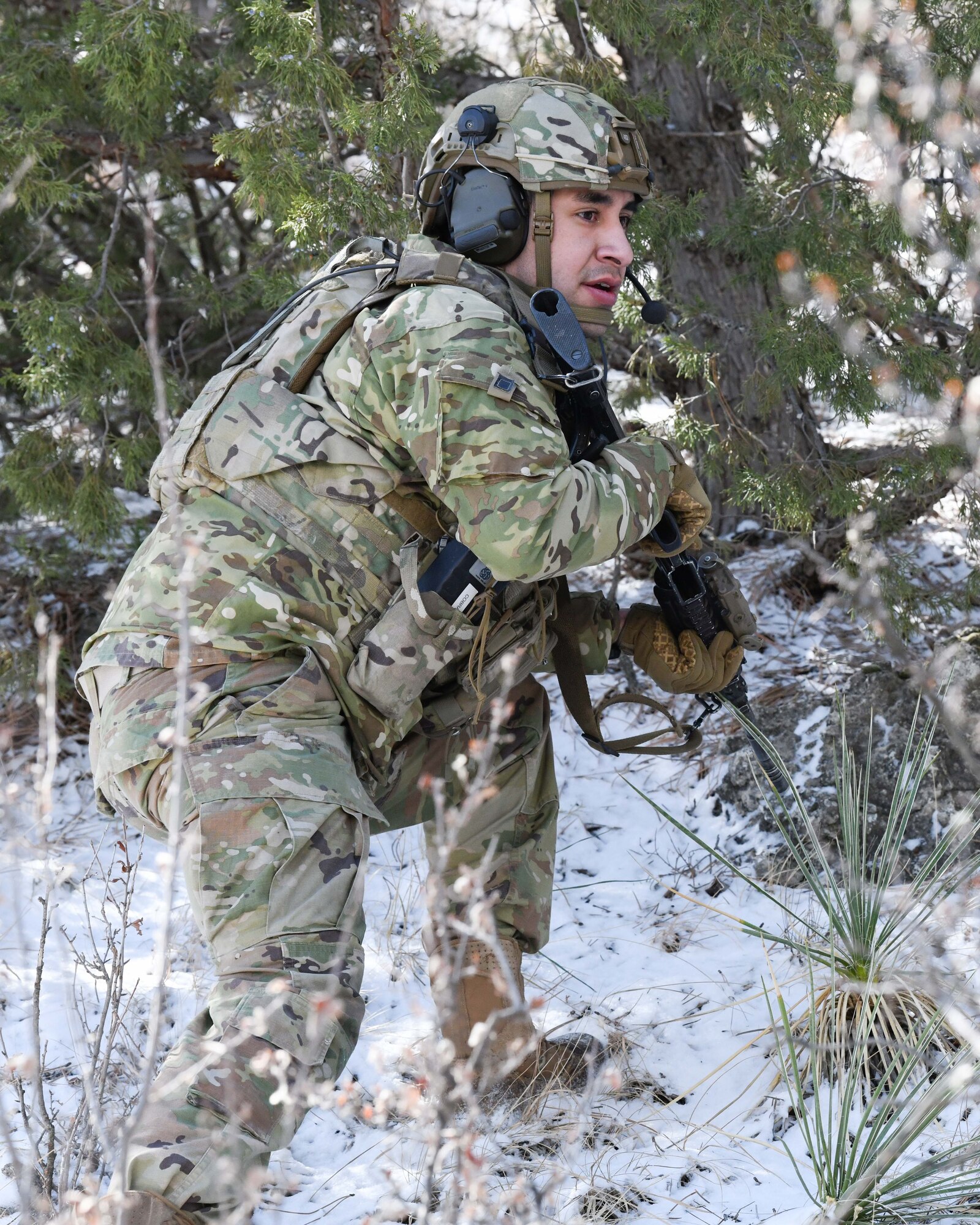 Senior Airman Pablo Archuleta, convoy response force leader at the 90th Missile Security Operations Squadron, sweeps a tree line for adversaries after a simulated payload transporter attack in Pine Bluffs, Wyoming, March 30, 2022. The 90th Security Forces Group conducted full mission profile training to further develop response capabilities to contingency situations during a PT movement. (U.S. Air Force photo by Airman 1st Class Charles Munoz)
