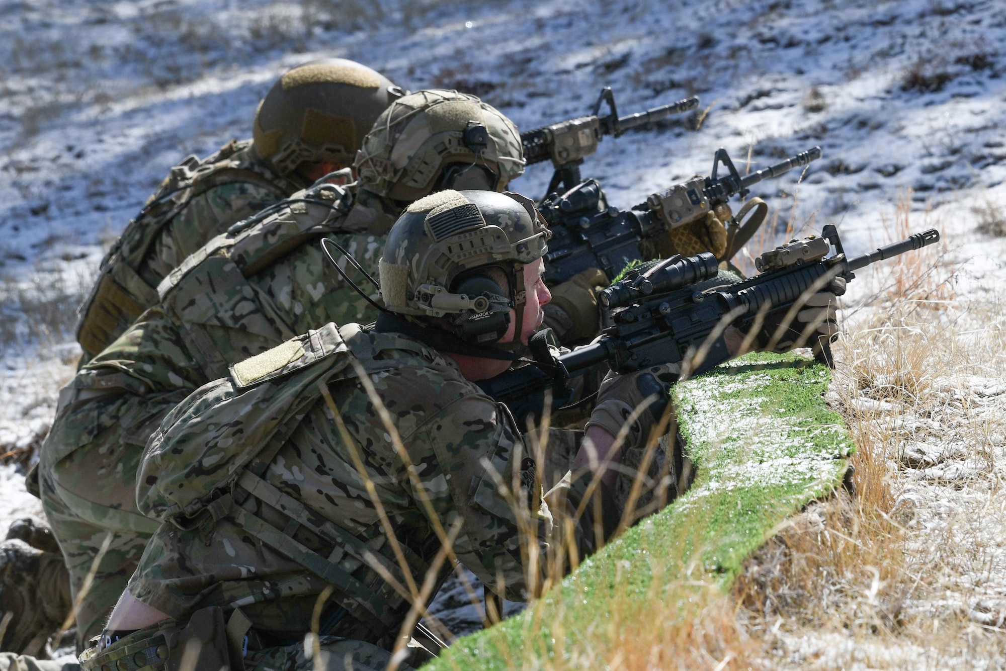 Convoy response force leaders from the 90th Missile Security Operations Squadron sweep a tree line for adversaries after a simulated payload transporter attack in Pine Bluffs, Wyoming, March 30, 2022. The 90th Security Forces Group conducted full mission profile training to further develop response capabilities to contingency situations during a PT movement. (U.S. Air Force photo by Airman 1st Class Charles Munoz)