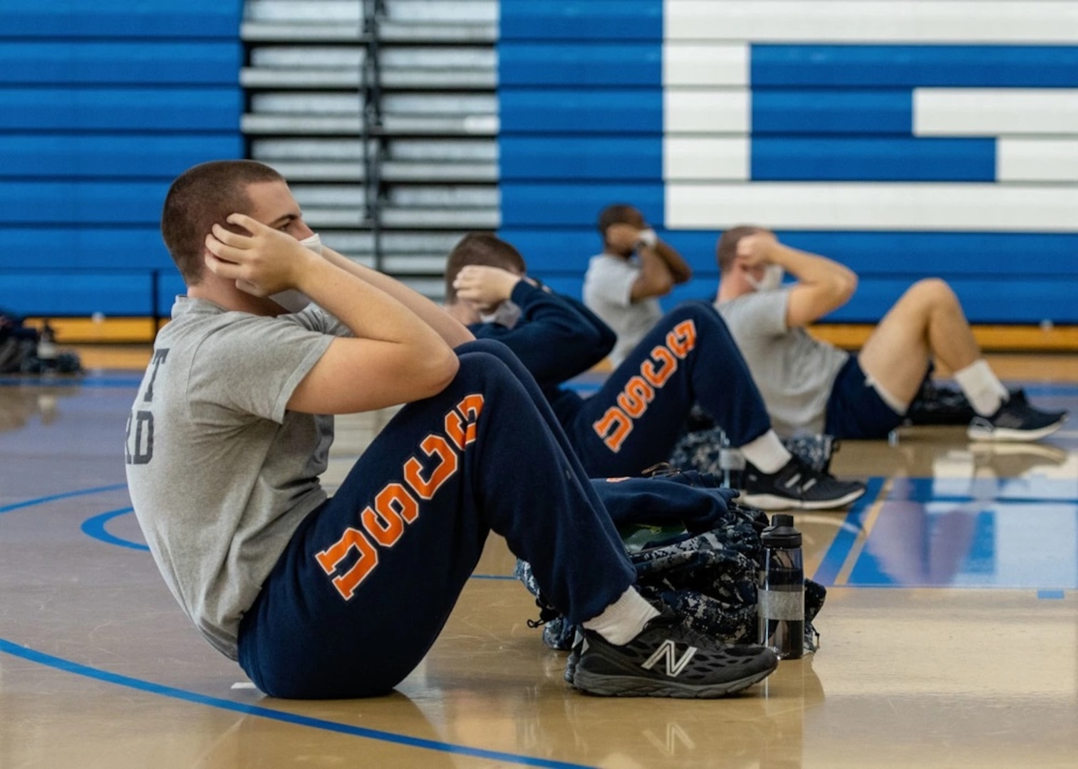 Recruits from company Sierra-199 do sit-ups in the gym at U.S. Coast Guard Training Center Cape May, N.J., as part of their modified training schedule, Jan. 7, 2021. Training Center Cape May’s mission is to deliver dynamic training that sets the foundation for the Coast Guard’s professional culture and develops job-ready skills in our recruits to build our workforce for generations to come. (U.S. Coast Guard photo by Seaman Josalyn Brown)