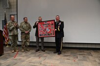 Brig. Gen. Tyler Smith, (right), receives a shadow box from the command team of the Utah National Guard showcasing awards and assignments from throughout his military career at his retirement ceremony, March 14, 2022, at Camp Williams, Utah.