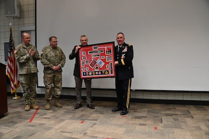 Brig. Gen. Tyler Smith, (right), receives a shadow box from the command team of the Utah National Guard showcasing awards and assignments from throughout his military career at his retirement ceremony, March 14, 2022, at Camp Williams, Utah.