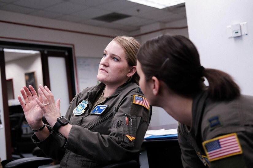Two women discuss during a pre-flight brief