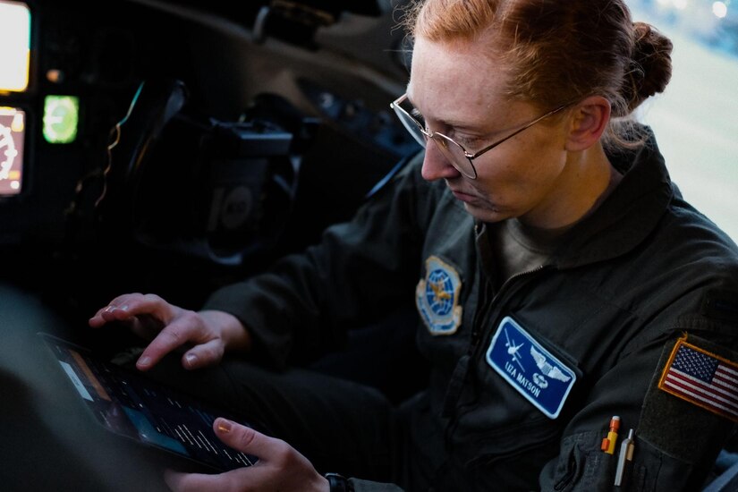 Woman conducts preflight check in cockpit of KC-10