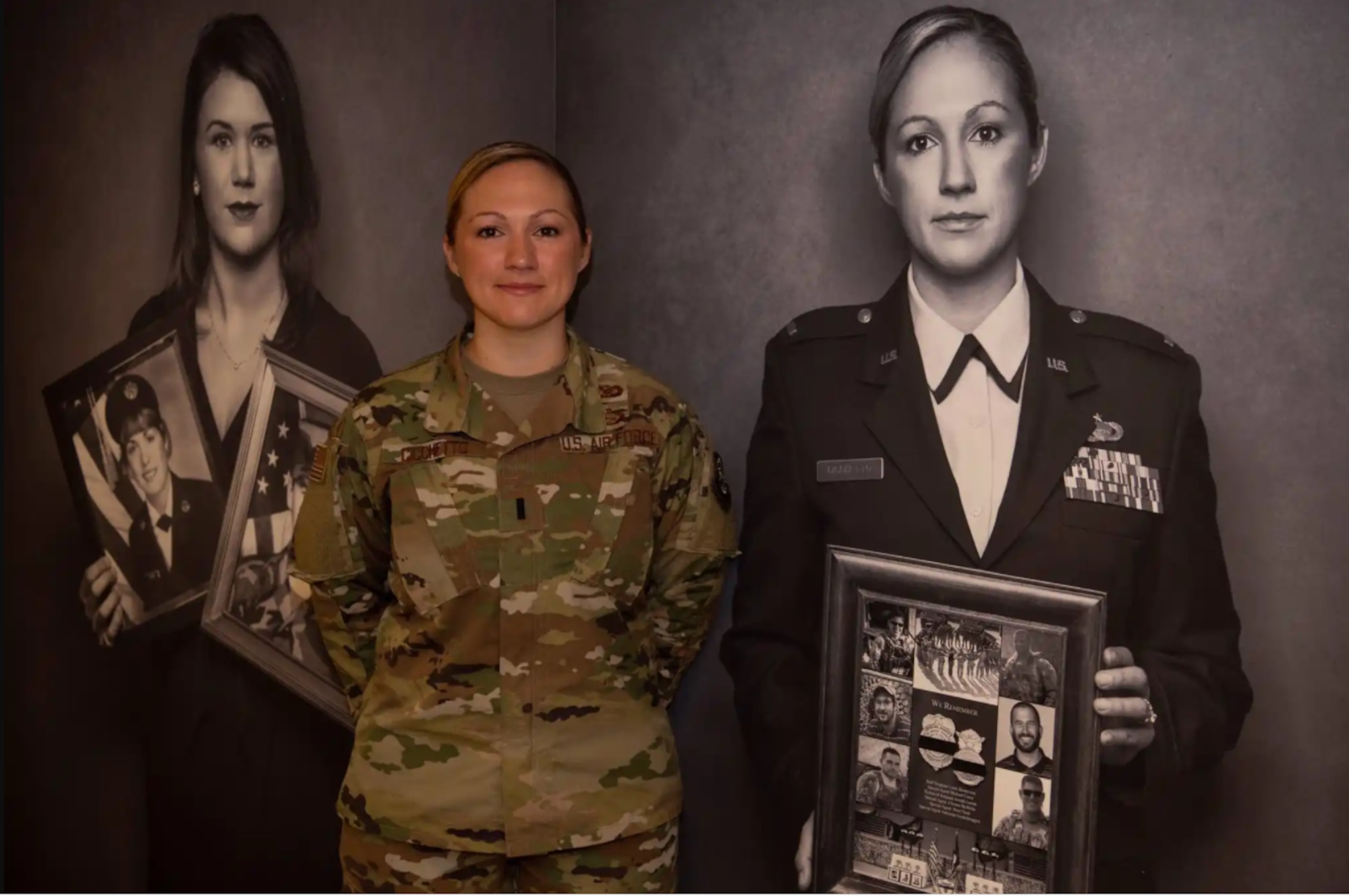 Then 1st Lt. Jessica Cichetto poses next to a photograph of herself during a gathering at the "We Will Tell Their Stories" photo exhibit