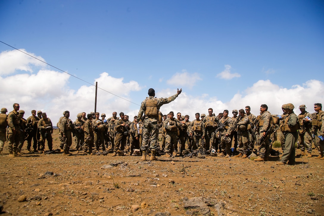U.S. Marine Corps Staff Sergeant Mikelot A. Edouard, battalion mess chief with 1st Battalion, 12th Marines, 3rd Marine Division, gives a brief prior to teaching foraging techniques during Spartan Fury 22.1 at Pohakuloa Training Area, Hawaii, March 7, 2022. Individual Batteries procured local food and experimented with field cooking methods using lightweight, expeditionary equipment that is sustainable for long durations in austere environments. Spartan Fury is a Battalion level training exercise designed to refine long-range communications through naval asset integration, mission processing from battalion to firing sections, and 21st Century Foraging.