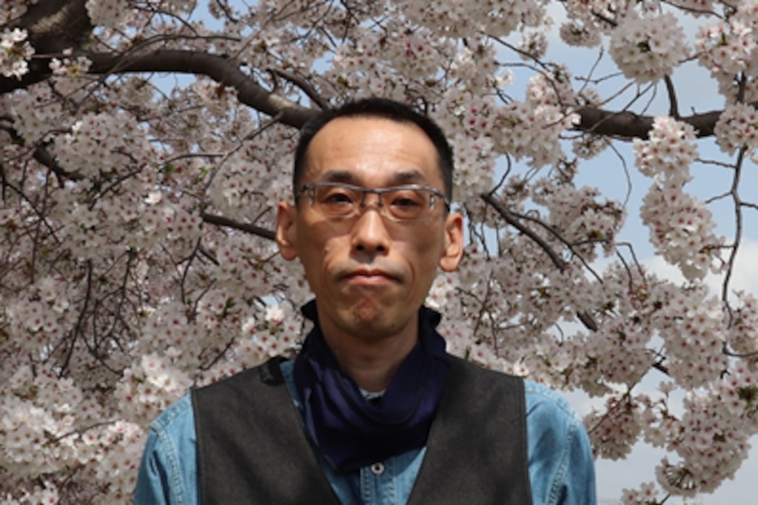 Man in front of white blossom tree