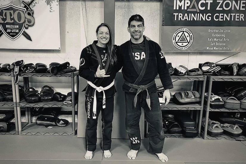 Two people stand for a photo at a gym.