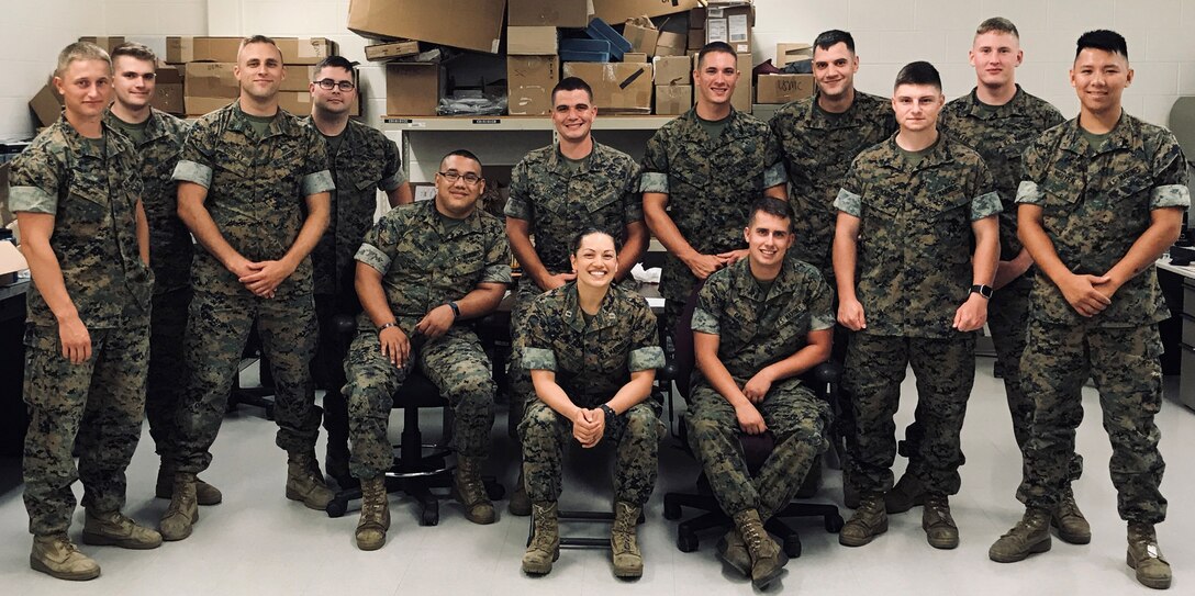 Marines in uniform pose for a photo.