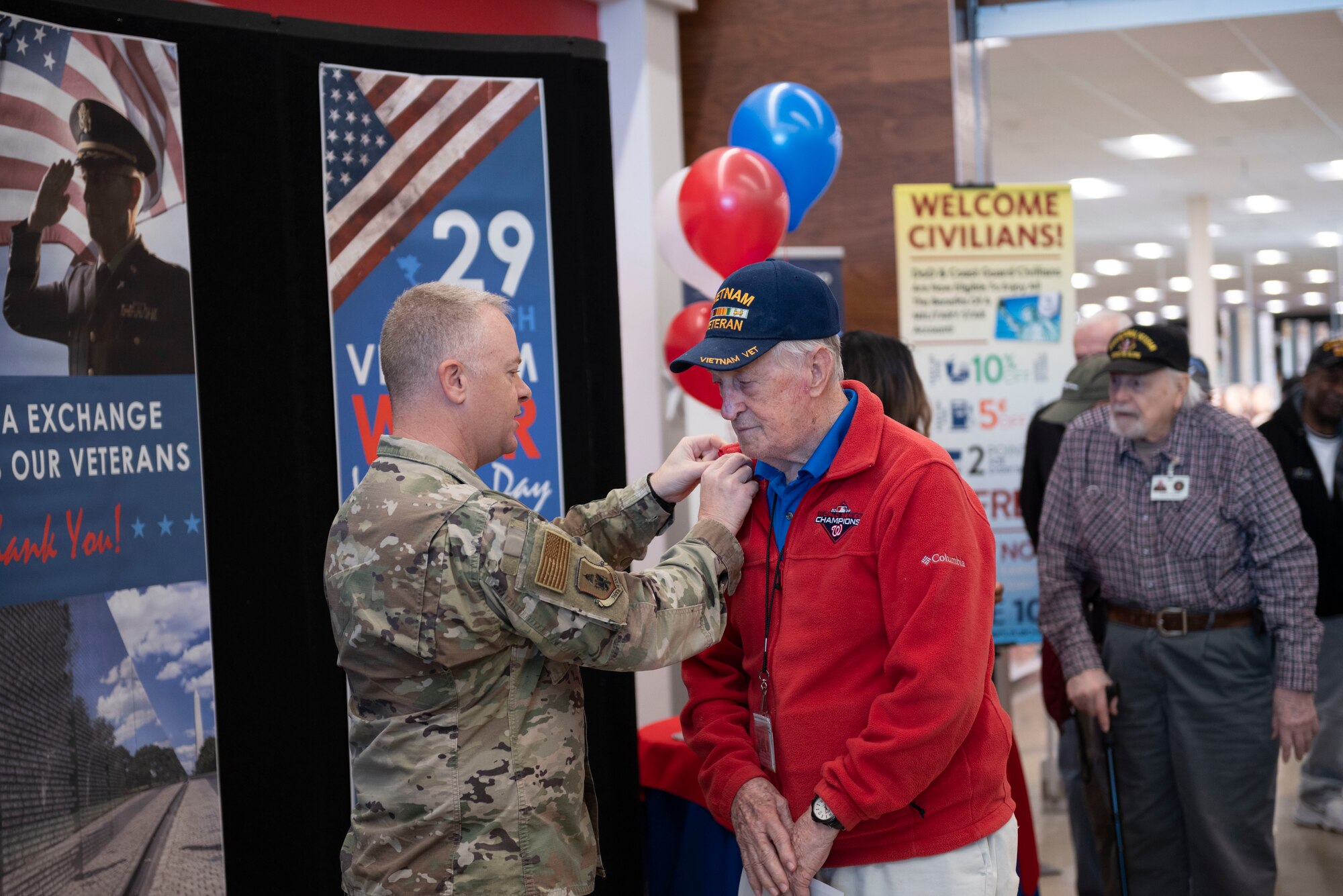 Col. Tyler Schaff, 316th Wing and installation commander, awards a Vietnam War veteran a commemorative pin, March, 29, 2022 at Joint Base Andrews, Md.