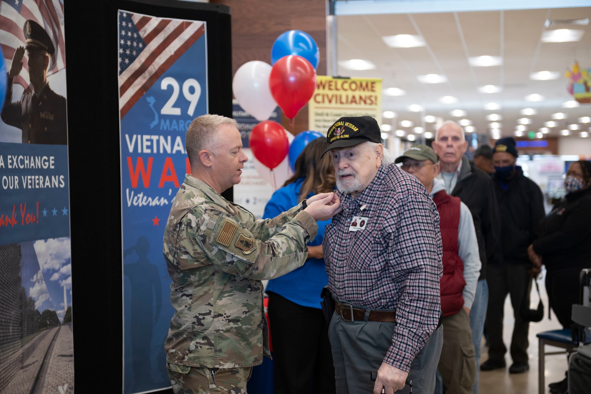 Col. Tyler Schaff, 316th Wing and installation commander, awards a Vietnam War veteran a commemorative pin, March, 29, 2022 at Joint Base Andrews, Md.