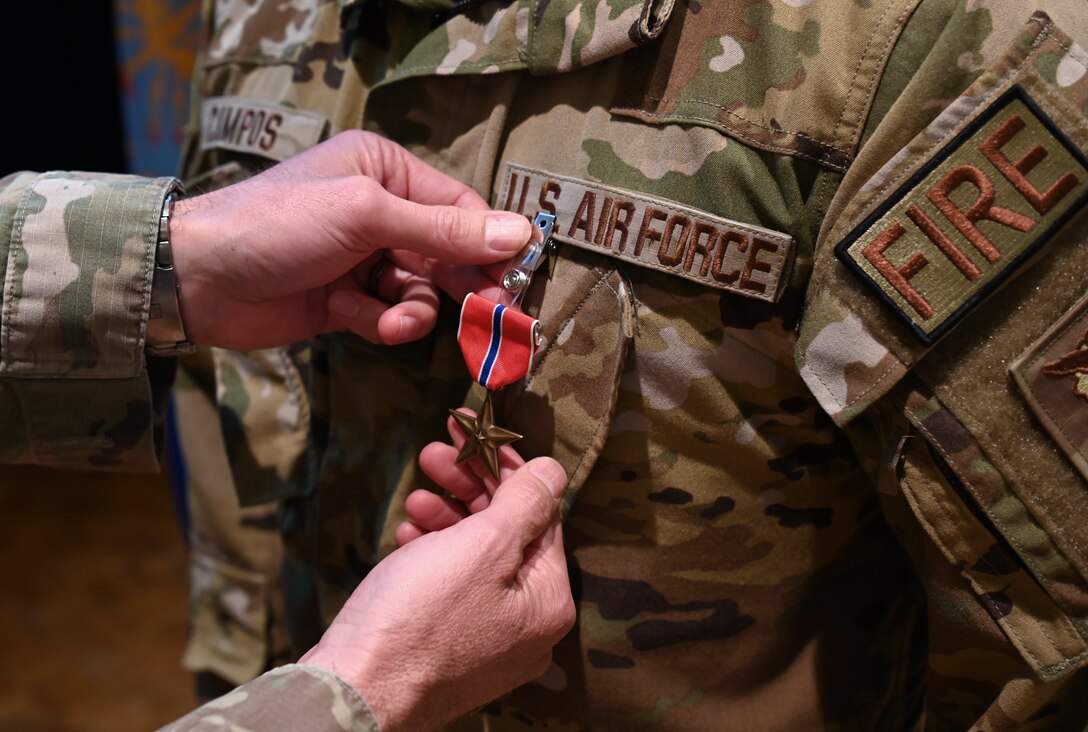 Lt. Col. Charles Hansen, 30th Civil Engineer Squadron commander, pins a Bronze Star Medal on MSgt. Roy Campos, 30th Civil Engineer Squadron readiness division chief on Vandenberg Space Force Base, Calif., March 31, 2022. Campos’ actions contributed to more than 300 successful rescue missions that evacuated more than 124,000 personnel, making it the largest human airlift in history. (U.S. Space photo by Airman 1st Class Tiarra Sibley)