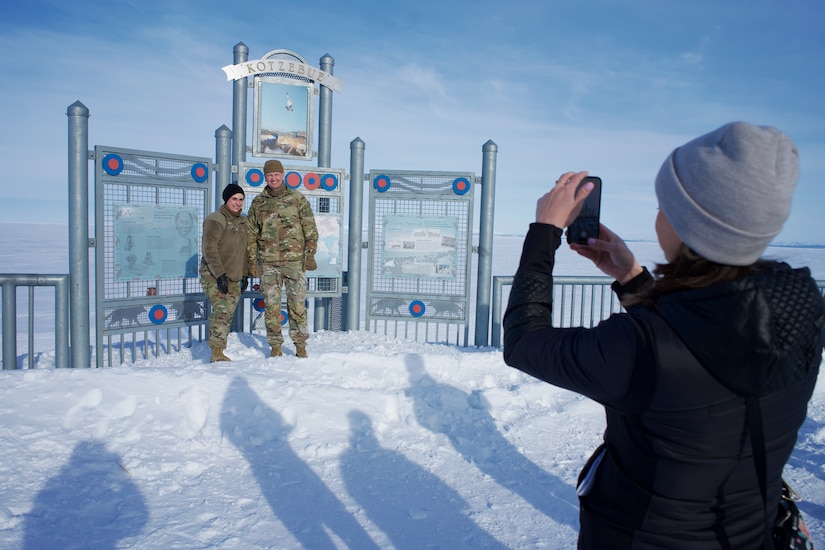 JOINT BASE ELMENDORF-RICHARDSON, Alaska -- Azara Mohammadi, Alaska National Guard tribal liaison, photographs Brig. Gen. Jackie Huber and Col. Brock Larson National Guard Arctic Interest Council delegates representing the North Dakota National Guard March 29, 2022, at the Kotzebue, Alaska, sea wall overlooking the frozen Chukchi Sea. The NG-AIC provides a forum of representatives and subject matter experts from States with Arctic interests, capabilities and resources. (Alaska National Guard photo by Capt. David Bedard)