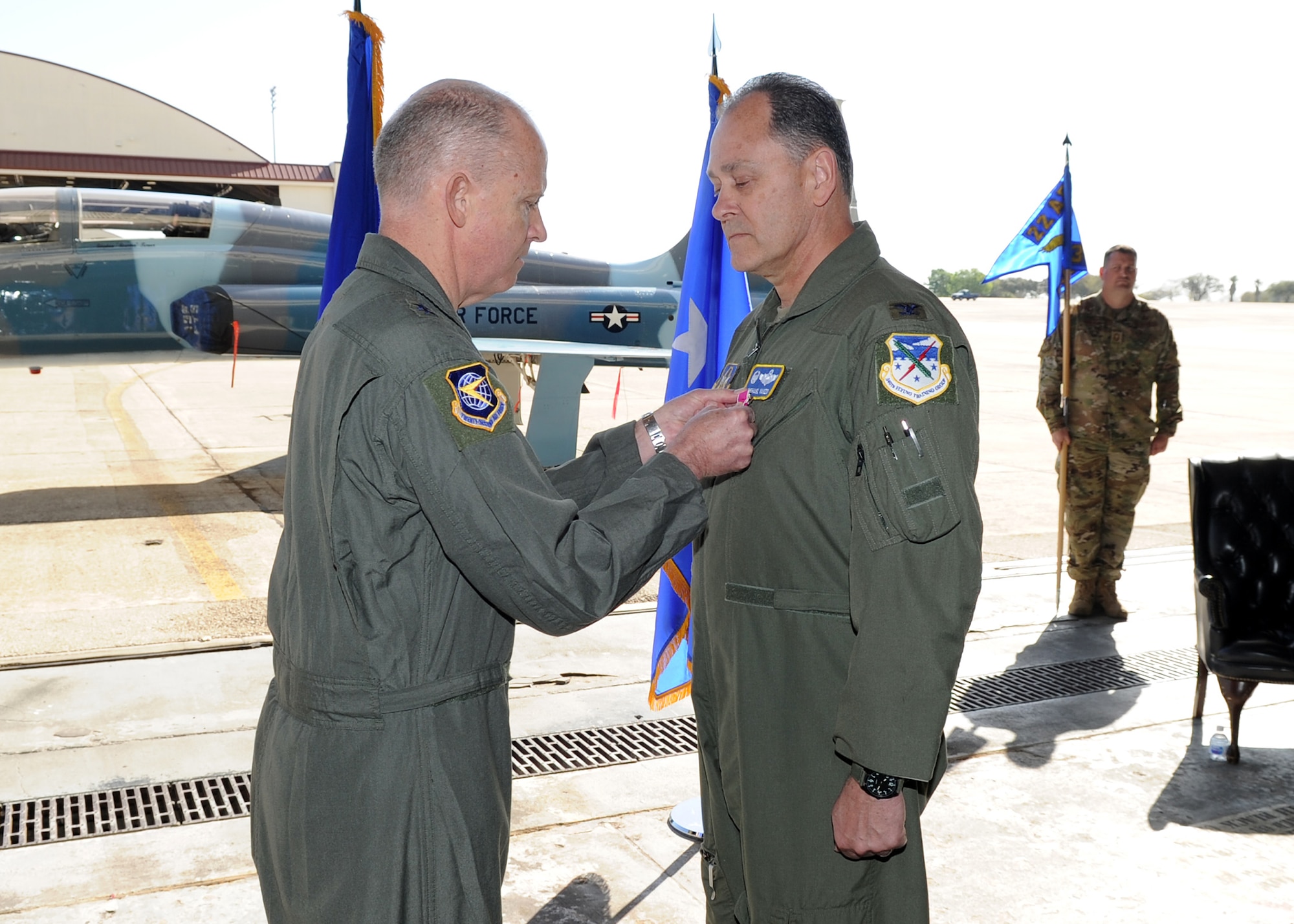 Maj. Gen. Bret C. Larson, 22nd Air Force commander, presents the U.S. Department of Defense’s Legion of Merit to Col. Michael Vanzo, 340th Flying Training Group outgoing commander, during an official change of command ceremony conducted at Joint Base San Antonio-Randolph, Texas, on Mar. 31, 2022.