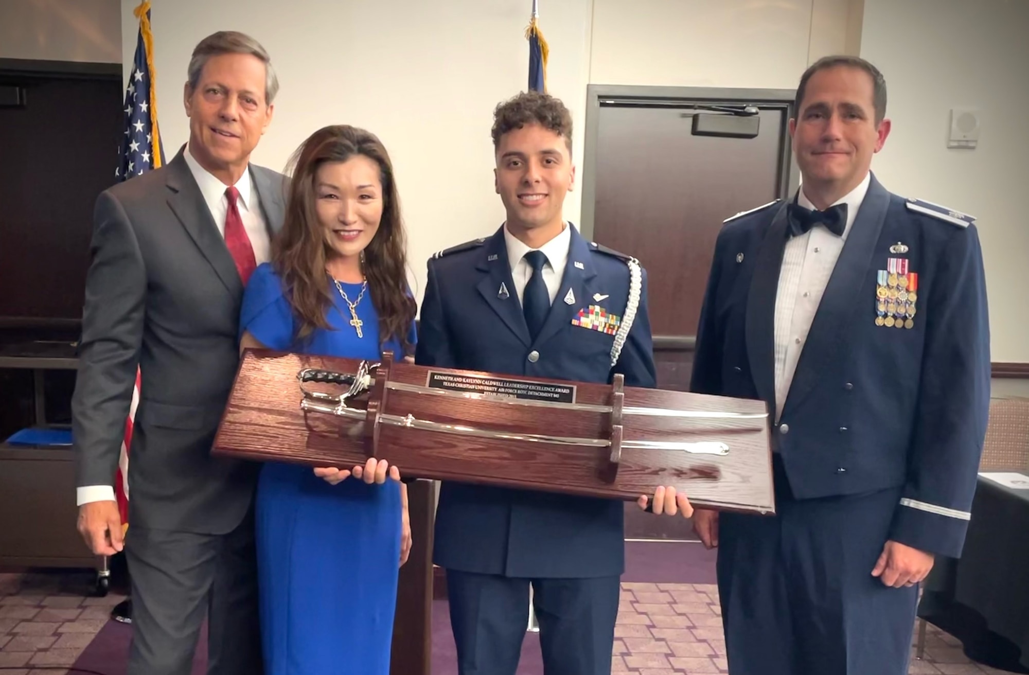 (left to right) Kenneth and Kaylynn Caldwell present Air Force ROTC Detachment 845 Cadet 1st Lt. Keven Fuentes with the Kenneth and Kaylynn Caldwell Leadership Excellency Award, as Lt. Col. James Fagan, AFROTC Det. 845 commander, looks on at the detachment’s Spring Dining Out in Fort Worth, Texas, April 23. The award is presented to a senior who is selected for showing exceptional initiative, character and who makes a lasting impact within the detachment. The award also comes with a $5,000 scholarship. (U.S. Air Force photo by Master Sgt. Jeremy Roman)