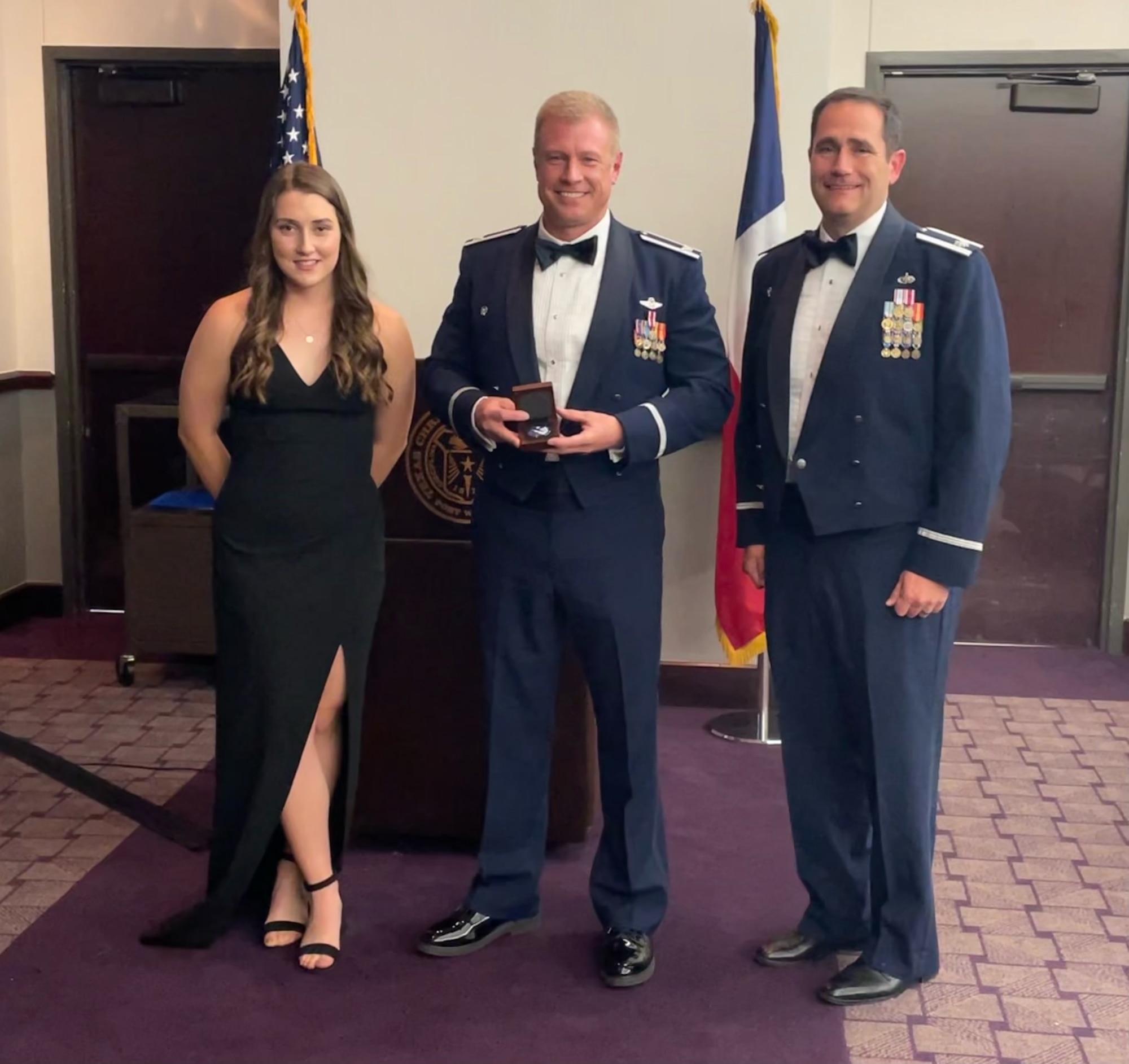 (left) Air Force Reserve Officer Training Corps Detachment 845 Cadet Rebekah Premenko, the event's narrator, and (right) Lt. Col. James Fagan, AFROTC Det. 845 commander, present 301st Fighter Wing Commander Col. Allen Duckworth, the event's keynote speaker with a detachment coin at the Texas Christian University AFROTC Det. 845 Spring Dining Out Ceremony, April 23. This military tradition can be traced back prior to WWI and WWII where victories and feats of heroism are celebrated in order to bring about cohesion and camaraderie within a specific unit. (U.S. Air Force photo by Master Sgt. Jeremy Roman)