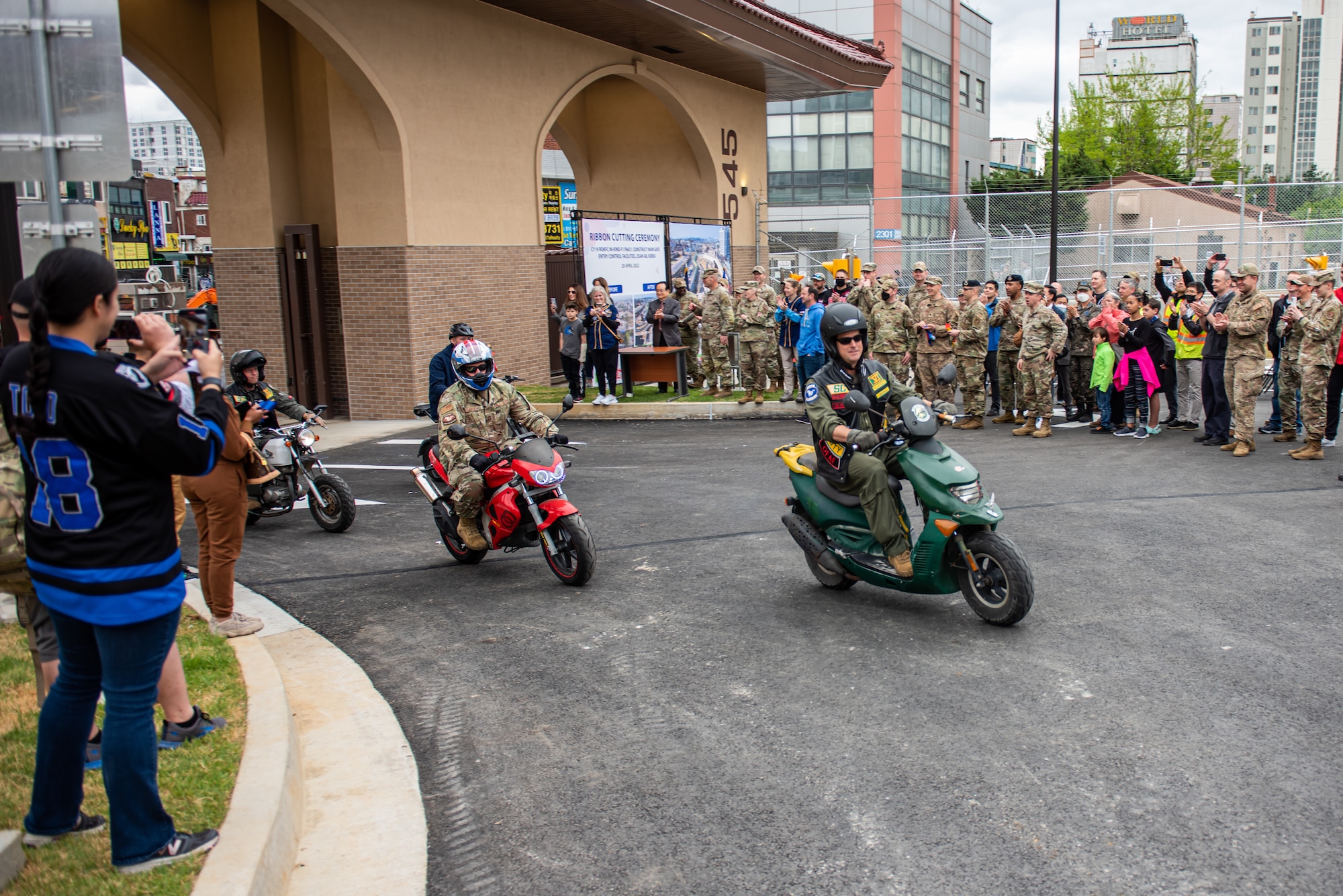 Col. Joshua Wood, 51st Fighter Wing commander, and Chief Master Sgt. Justin Apticar, 51st FW command chief, ride their personal transportation devices through the main gate April 29, 2022 at Osan Air Base, Republic of Korea.