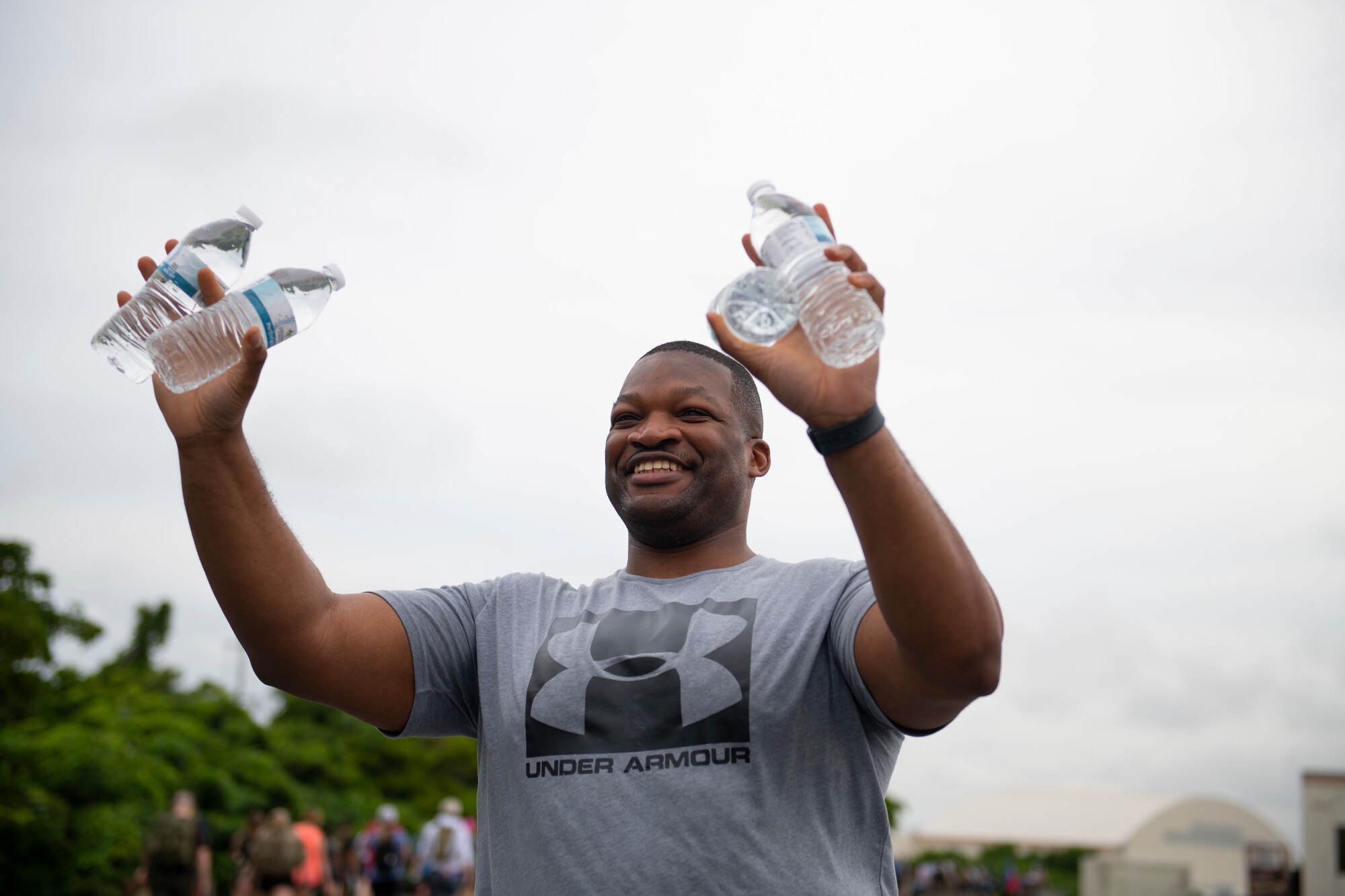 Master Sgt. Piankhy Richberg, 18th Wing Equal Opportunity Office deputy director, holds up water bottles for participants in the 9th Annual Memorial for the Bataan Death March at Kadena Air Base, Japan, April 23, 2022. There were six water stations set up throughout the 8.5-mile route around the 18th Wing flightline. (U.S. Air Force photo by Senior Airman Jessi Monte)