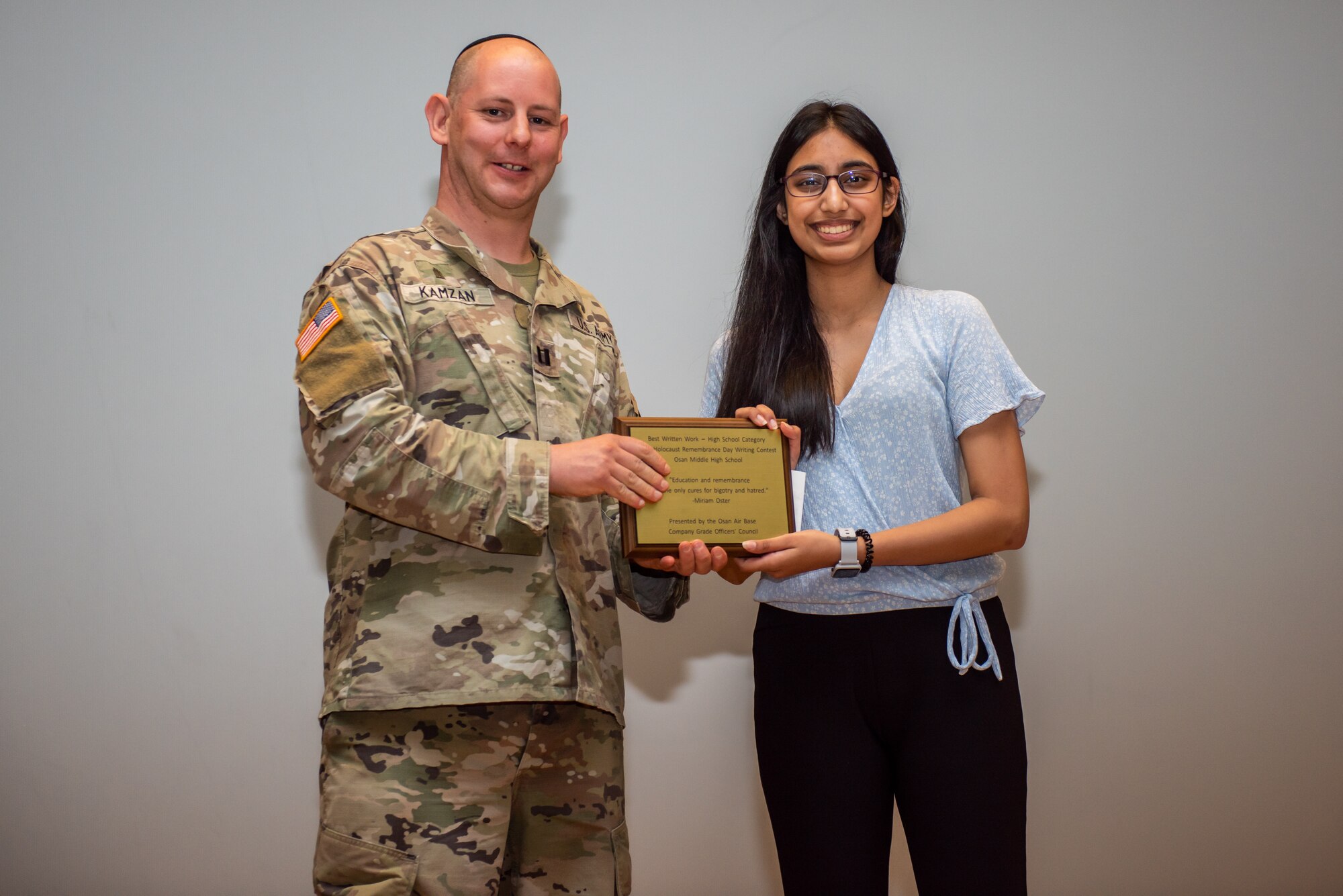 U.S. Army CPT Daniel Kamzan, 23d Chemical, Biological, Radiological and Nuclear Battalion Chaplain at Camp Humphreys, presents Ari Ramdatt, Osan Middle High School student, with an award for the Holocaust Rememberance Day writing contest April 28, 2022 at Osan Air Base, Republic of Korea.