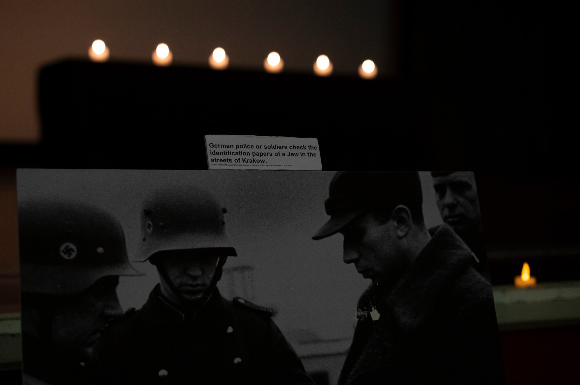 Photos and information pertaining to events during the holocaust are displayed around the stage during a Days of Remembrance candlelight ceremony at Kadena Air Base, Japan, April 25, 2022. The U.S. Congress established the Days of Remembrance as the nation’s annual commemoration of the Holocaust. (U.S. Air Force photo by Senior Airman Jessi Monte)