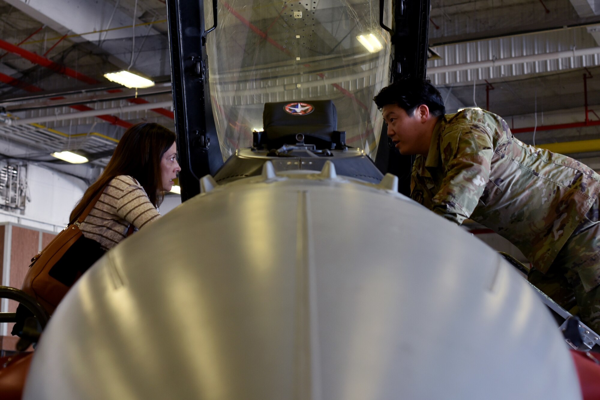 Cheryl Duckworth, Key Volunteers Program leader explores a F-16 Fighting Falcon with Staff Sgt. Andrew Kim, 301st Fighter Wing Maintenance Squadron egress technician at Naval Air Station Joint Reserve Base Fort Worth, Texas on May 1st , 2022. The F-16 Fighting Falcon is a compact, multi-role fighter aircraft. It is highly maneuverable and has proven itself in air-to-air combat and air-to-surface attack. (U.S. Air Force photo by Staff Sgt. Randall Moose)