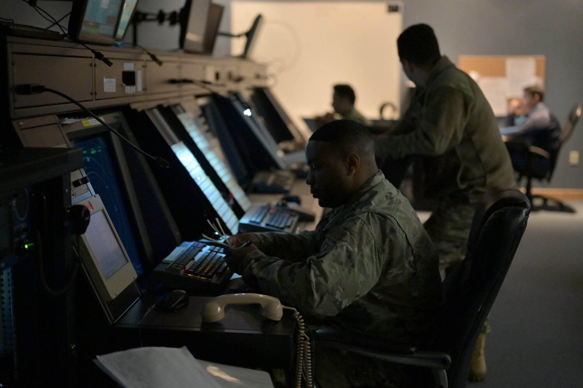 Service members working in an air traffic control facility.