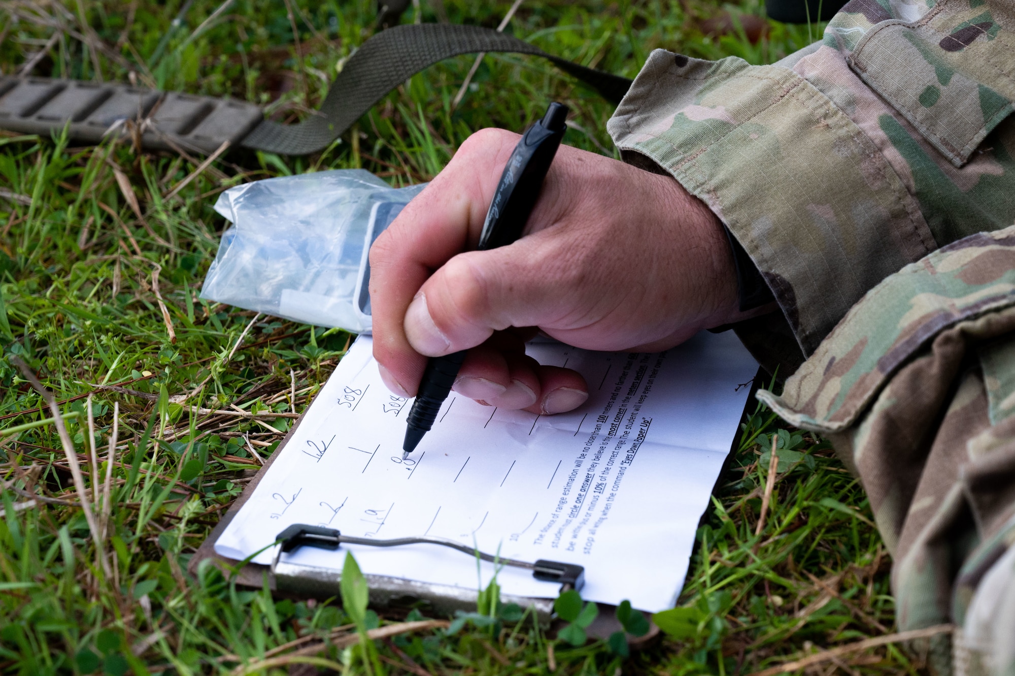 An Airman from the 19th Security Forces Squadron writes on a range card during an Advanced Designated Marksman course