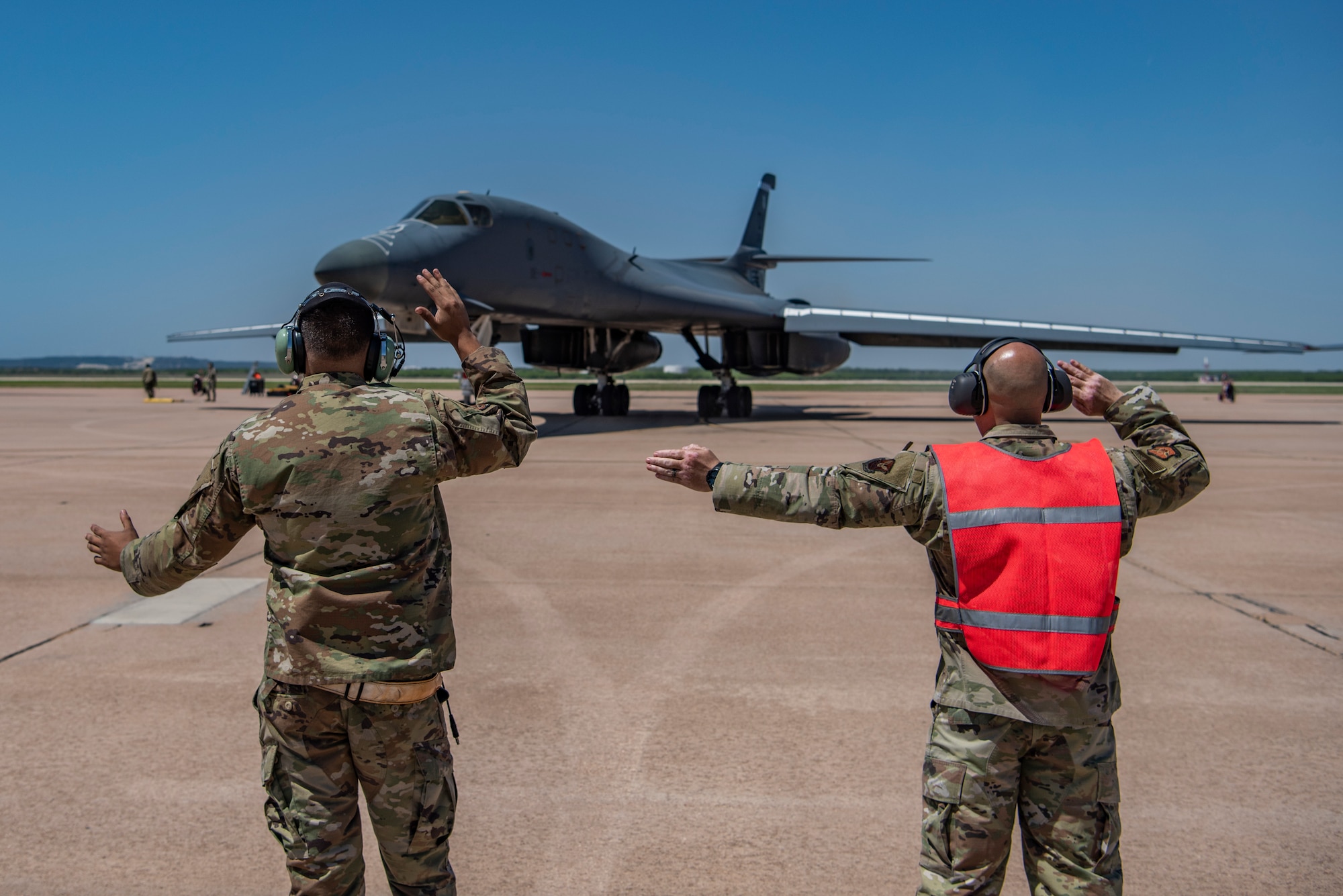 Chief Master Sgt. Steve Cenov, right, 8th Air Force command chief and Joint-Global Strike Operations Center senior enlisted leader, and Airman 1st Class Nicholas DeAnda, 7th Aircraft Maintenance Squadron crew chief, taxi a B-1B Lancer at Dyess Air Force Base, Texas, April 29, 2022. Crew chiefs organize aircraft maintenance and ensure all inspections are completed safely and correctly. (U.S. Air Force photo by Airman 1st Class Ryan Hayman)