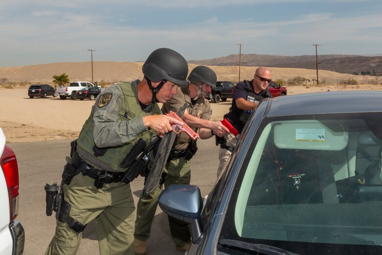 Police officers with the Provost Marshal Office react to an active shooter scenario and search vehicles during the Semper Durus Exercise held aboard Marine Corps Logistics Base Barstow, April 26, 2022