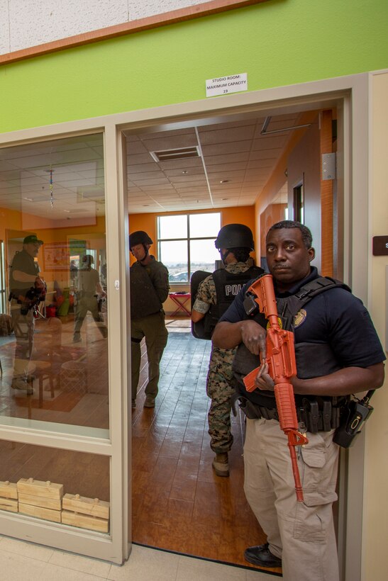 Police Officer Bernard Harrell, Provost Marshal's Office, maintains rear security as members of the security augmentation force conduct room clearing operations during Exercise Semper Durus held aboard Marine Corps Logistics Base Barstow, Calif., April 26, 2022.