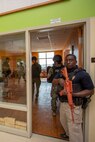 Police Officer Bernard Harrell, Provost Marshal's Office, maintains rear security as members of the security augmentation force conduct room clearing operations during Exercise Semper Durus held aboard Marine Corps Logistics Base Barstow, Calif., April 26, 2022.