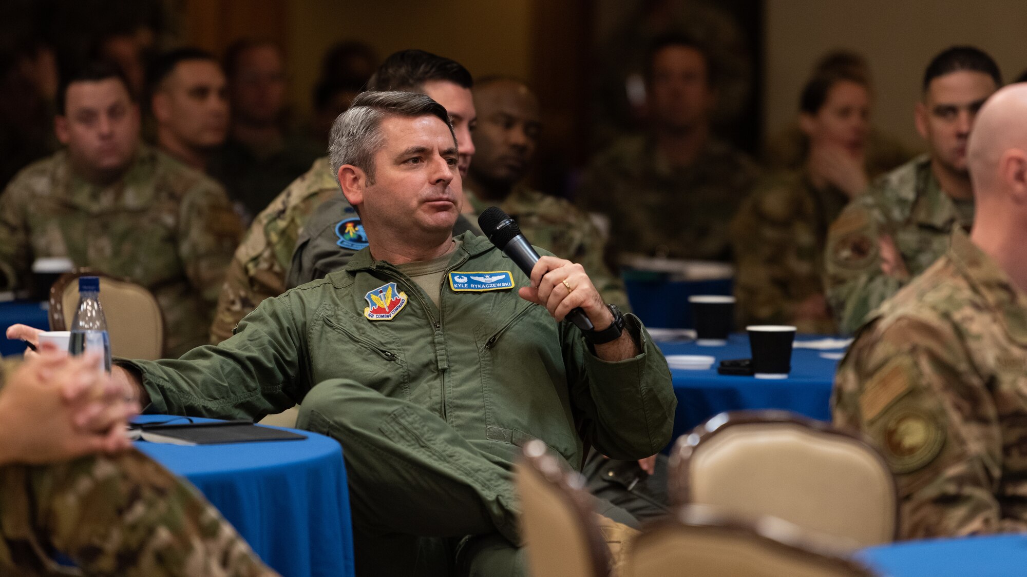 An Airmen speaks through a microphone.
