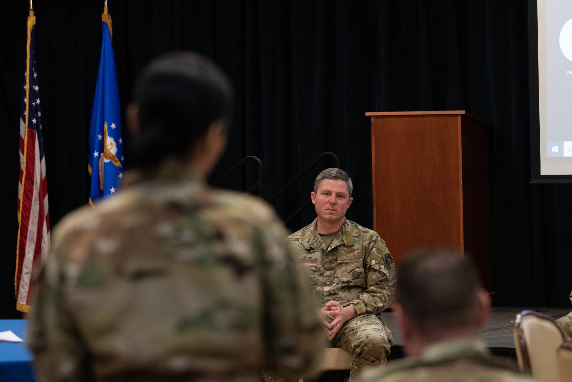 Brig. Gen. Conley sits and listens to an Airman asking a question.