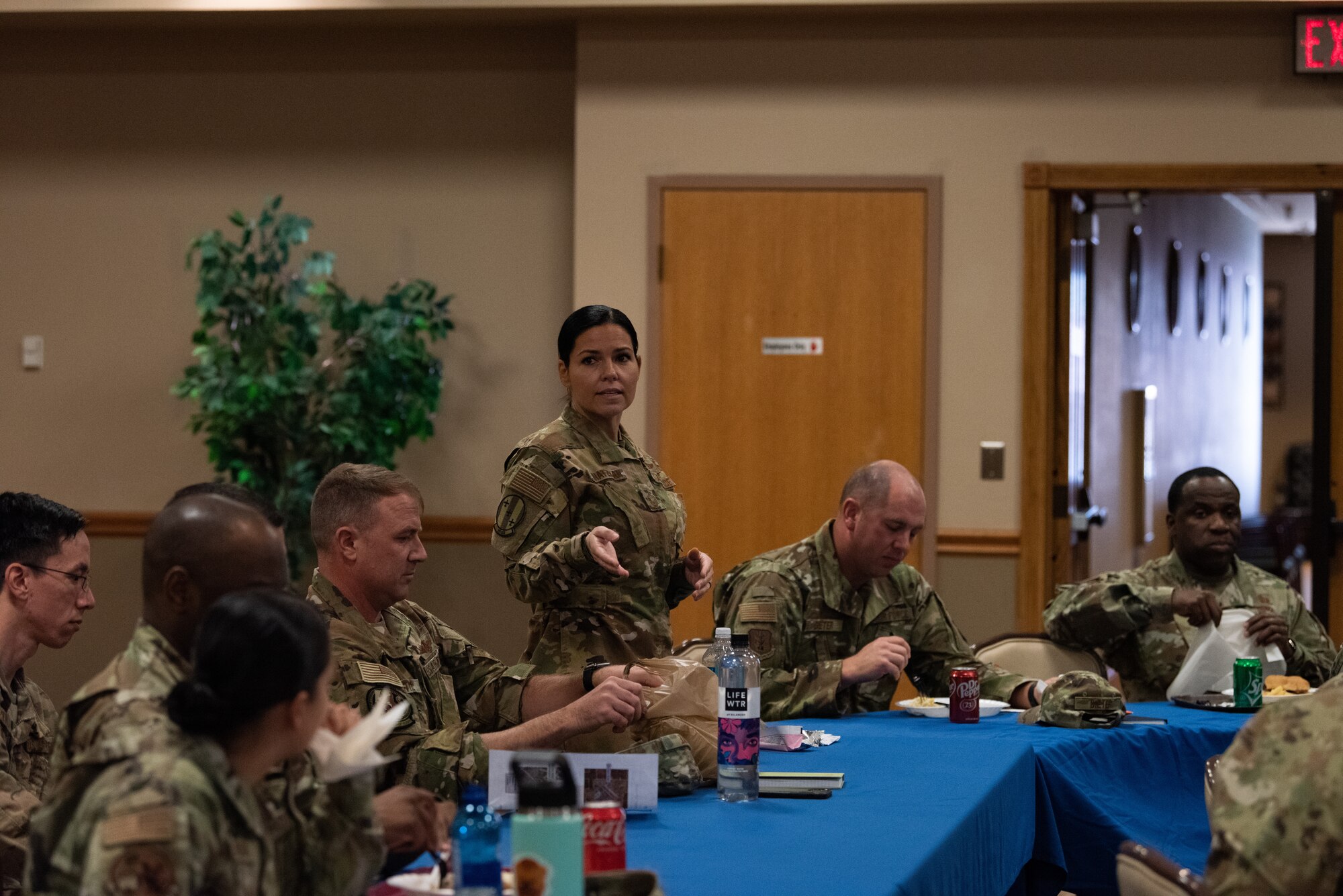 Senior Master Sgt. Schatzmans stands and speaks in a room full of Airmen and Guardians.
