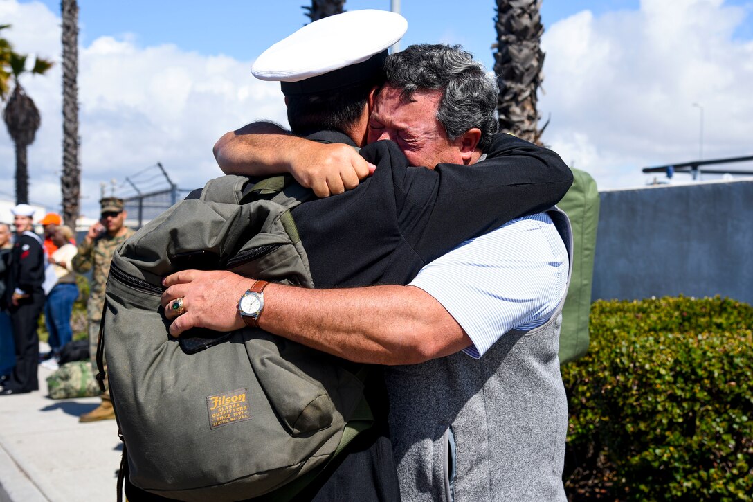 A sailor hugs his father.