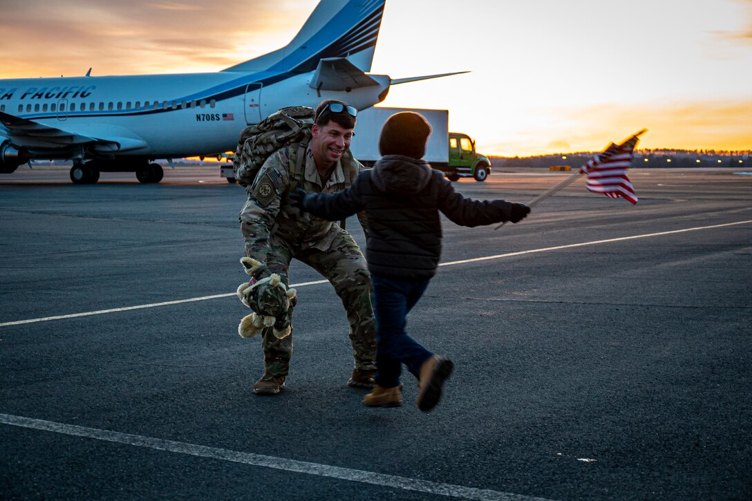 A Soldier assigned to the Connecticut National Guard's 1-102nd Infantry Regiment prepares to hug his son after returning home from a nearly year long deployment at the Army Aviation Support Facility in Windsor Locks, Connecticut Jan. 22, 2022. The 1-102nd was deployed to the Horn of Africa in support of Operation Enduring Freedom.