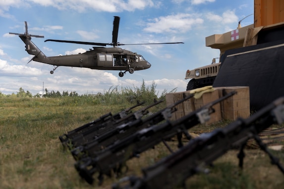 A UH-60 Black Hawk hovers near military equipment