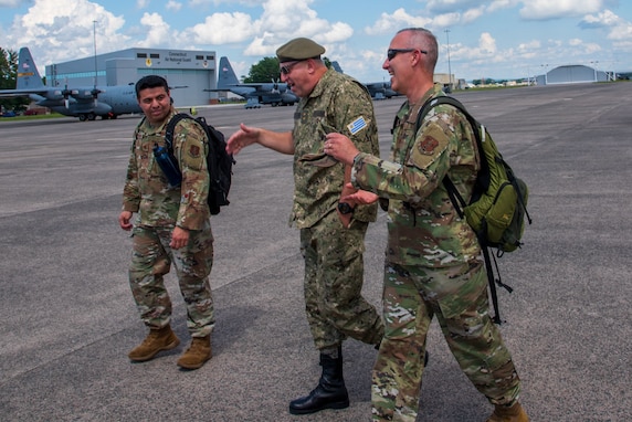 Military officers walking in front of aircraft hangar