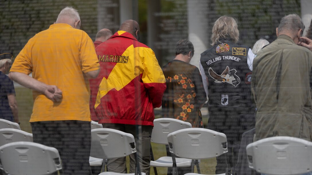 Retired U.S. military servicemembers and their families bow their heads during the final invocation of the Vietnam Veterans Recognition ceremony on Lejeune Memorial Gardens, Jacksonville, North Carolina, April 30, 2022. The ceremony honors all those who sacrificed while celebrating the accomplishments and perseverance of all Vietnam veterans. (U.S. Marine Corps photo by Lance Cpl. Antonino Mazzamuto)