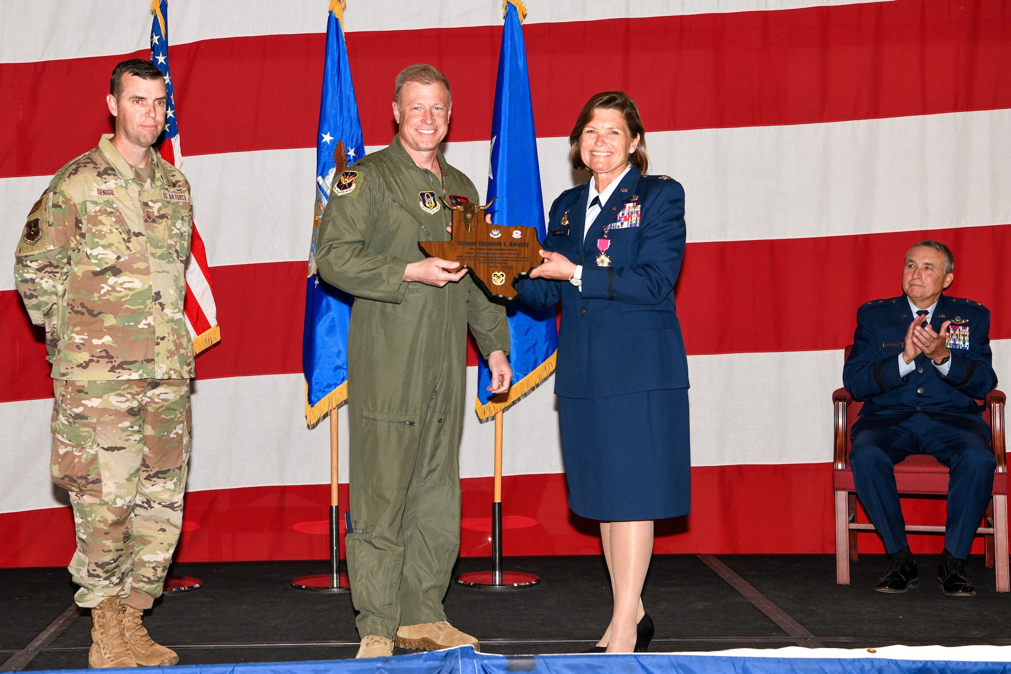 Colonel Elizabeth "Beth" Kwasny accepts and award from Colonel Allen Duckworth, commander of the 301st Fighter Wing, during a retirement ceremony on Saturday, April 30, 2022 at the Naval Air Station Joint Reserve Base Fort Worth, Texas. Kwasny served 31 years in the United States Air Force, both on Active Duty and as a traditional reservist.