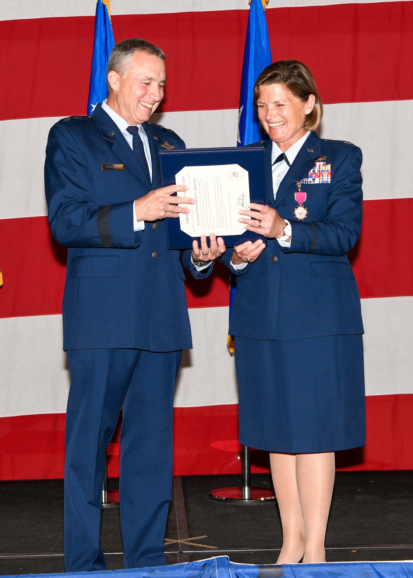 Colonel Elizabeth "Beth" Kwasny accepts a Certificate of Retirement from Major General John Breazeale during a retirement ceremony on Saturday, April 30, 2022. Kwasny served 31 years in the United States Air Force, both on Active Duty and as a traditional reservist.