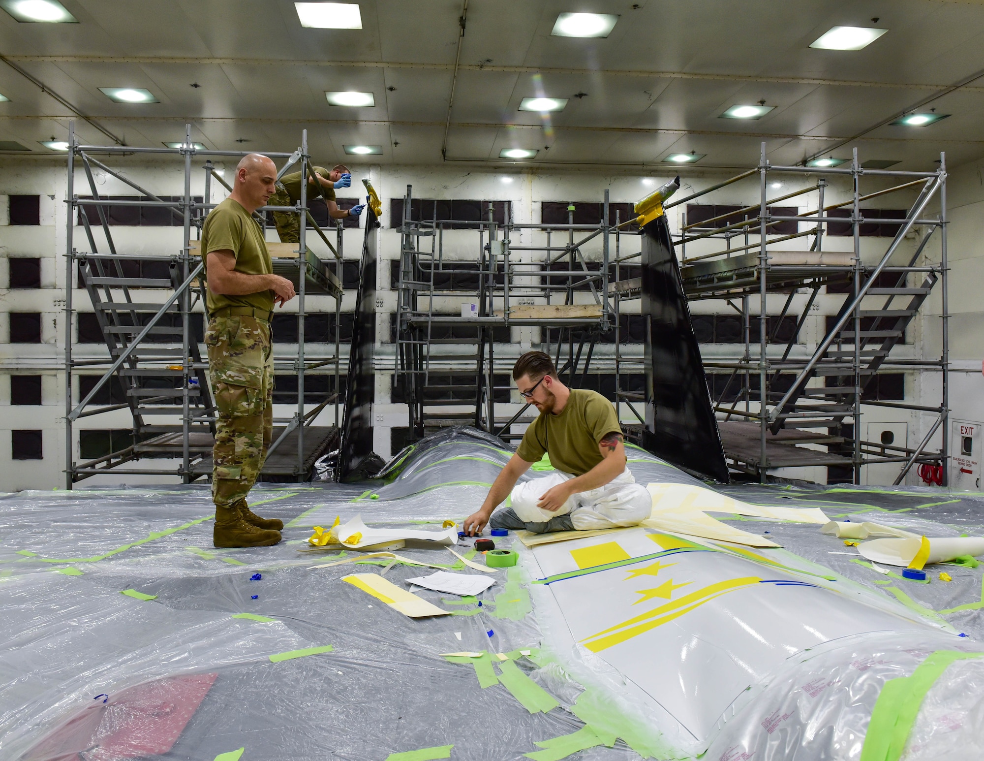 Tech. Sgt Gustav Monaco, 4th Equipment Maintenance Squadron Shift Supervisor, Staff Sgt. Chad Courwright,4th Equipment Maintenance Squadron combined tool kit custodian, examines measurements during the painting of  an F-15E Strike Eagle at Seymour Johnson Air Force Base, North Carolina, April 20, 2022. The paint is inspired by the 336th Fighter Generation Squadron emblem. (U.S. Air Force photo by Senior Airman Taylor Hunter)