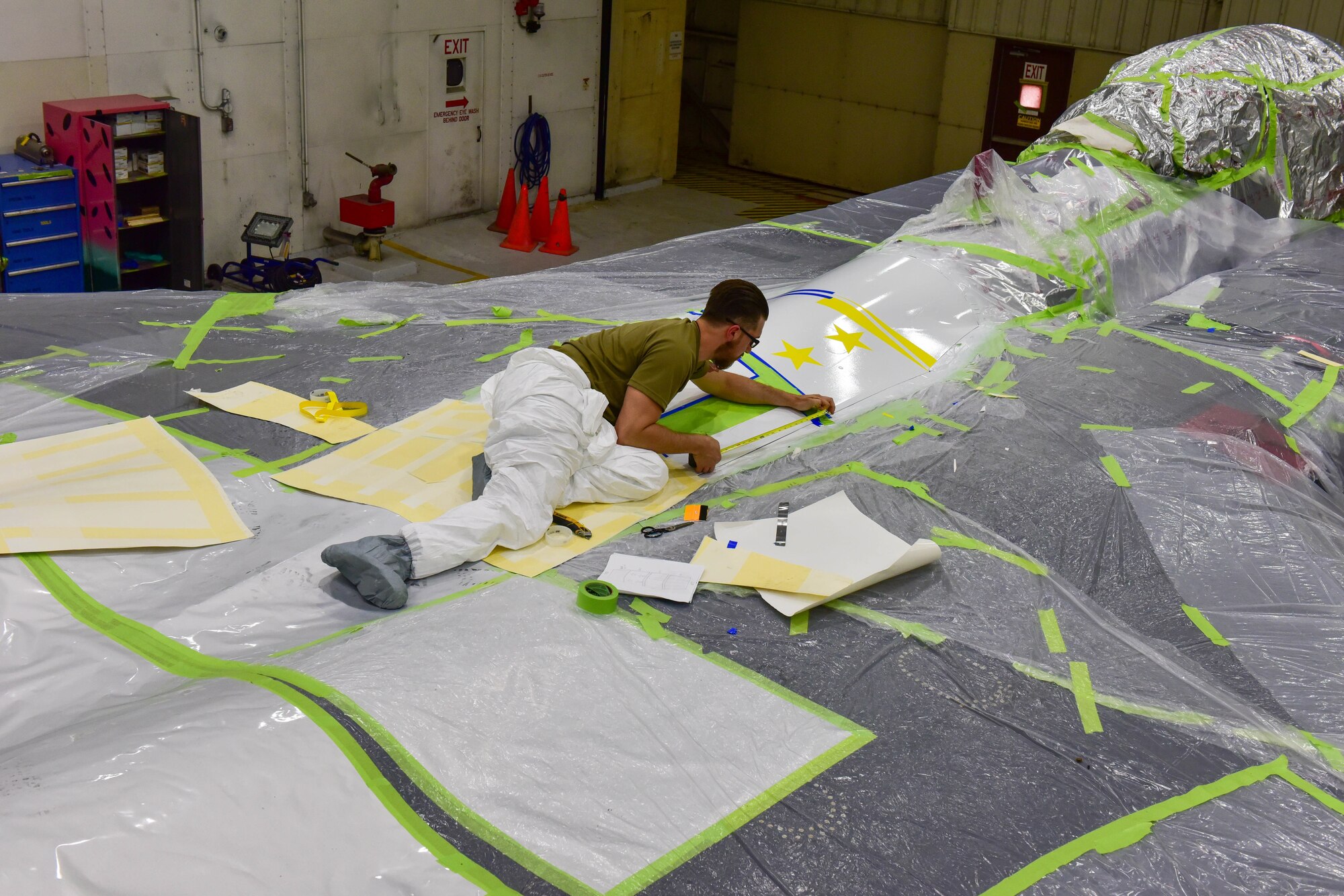 Staff Sgt. Chad Courtwright,  4th Equipment Maintenance Squadron combined tool kit custodian, places an outline for the custom paint job of an F-15E Strike Eagle at Seymour Johnson Air Force Base, North Carolina, April 20, 2022.The paint job was inspired by the original logo for the 336th Fight Generation squadron. (U.S. Air Force photo by Senior Airman Taylor Hunter)