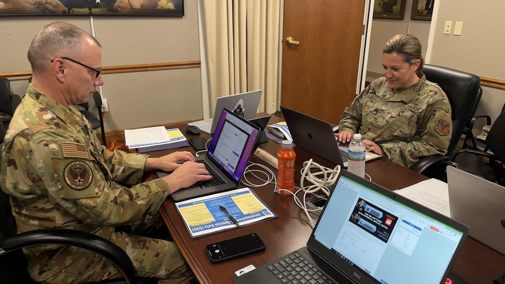 picture of wo people with laptops in a conference room