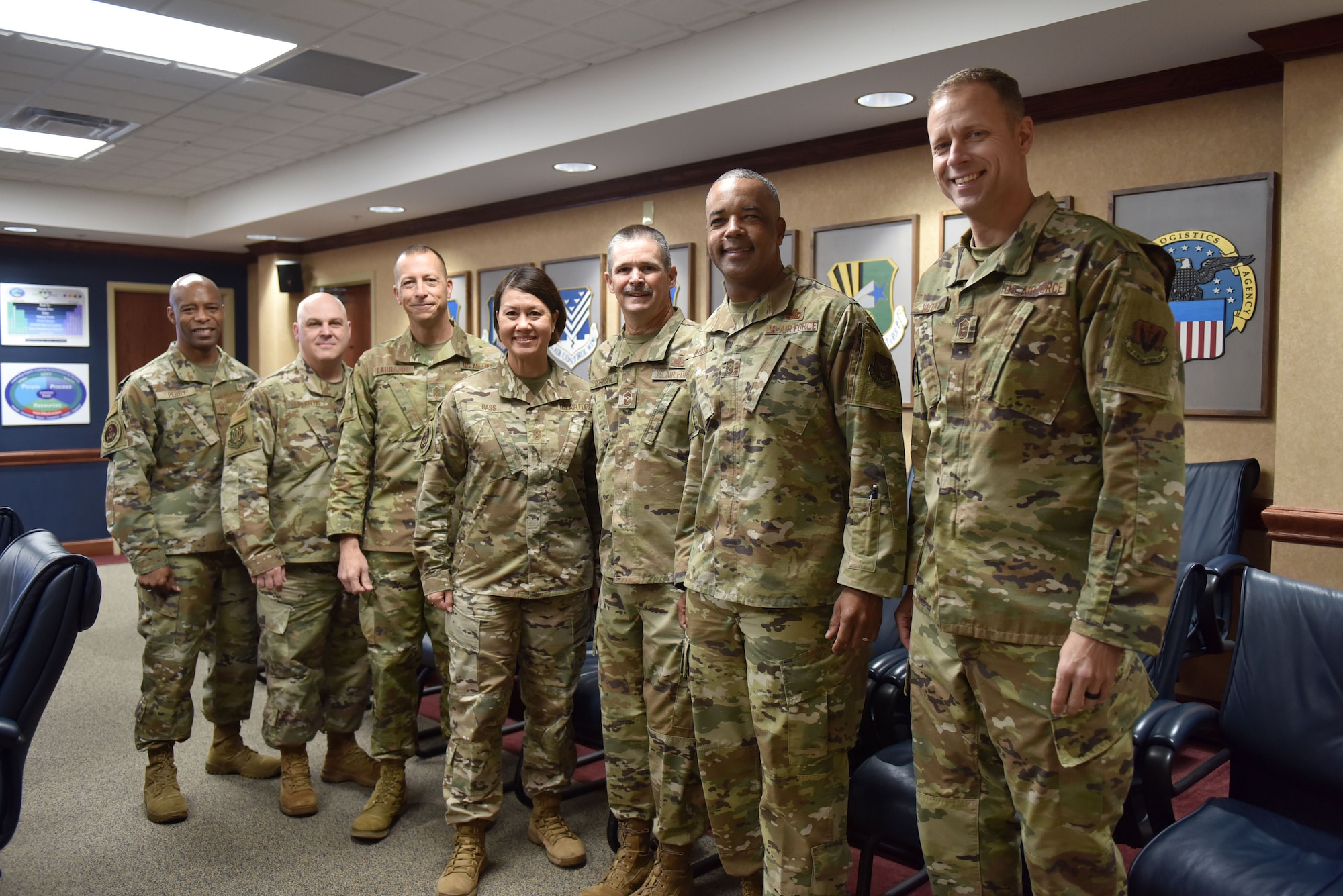 Airmen standing in conference room in a line posing for picture.