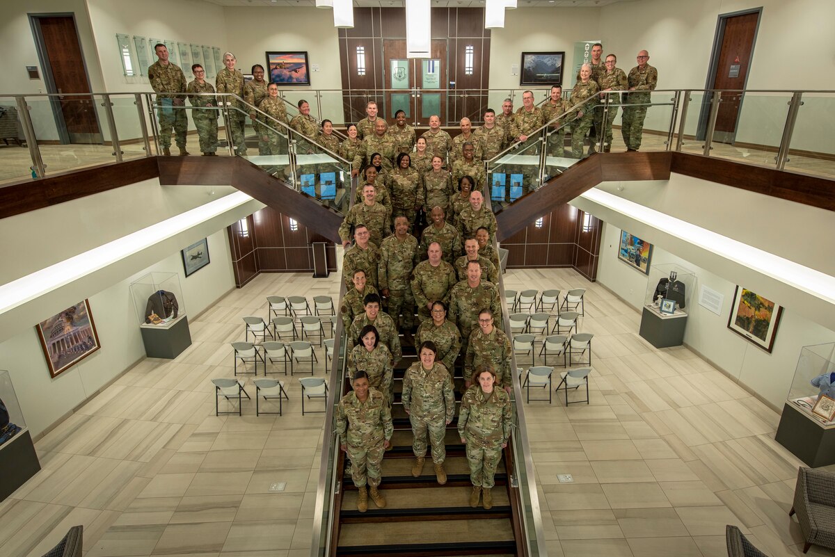 Large group of Airmen posing for photo on stairs.
