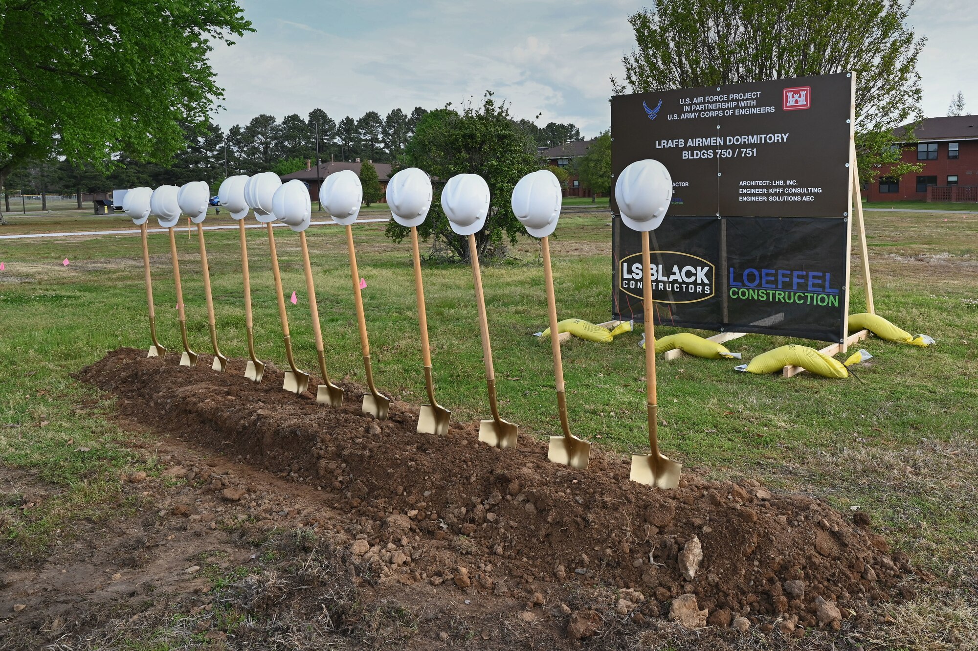 A row of shovels and hardhats is placed at the site of a new dormitory construction project during a groundbreaking ceremony