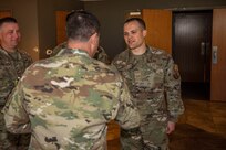 Senior Airman Jordan Heck, 7th Communications Squadron client systems apprentice, is coined by Maj. Gen. Andrew Gebara, 8th Air Force and Joint-Global Strike Operations Center commander, as the general visited Dyess Air Force Base, Texas, April 29, 2022. Airman Heck created a lightweight, mobile communications flyaway kit that provides connectivity to commercial internet and the Air Force’s unclassified network system. (U.S. Air Force photo by Airman 1st Class Ryan Hayman)