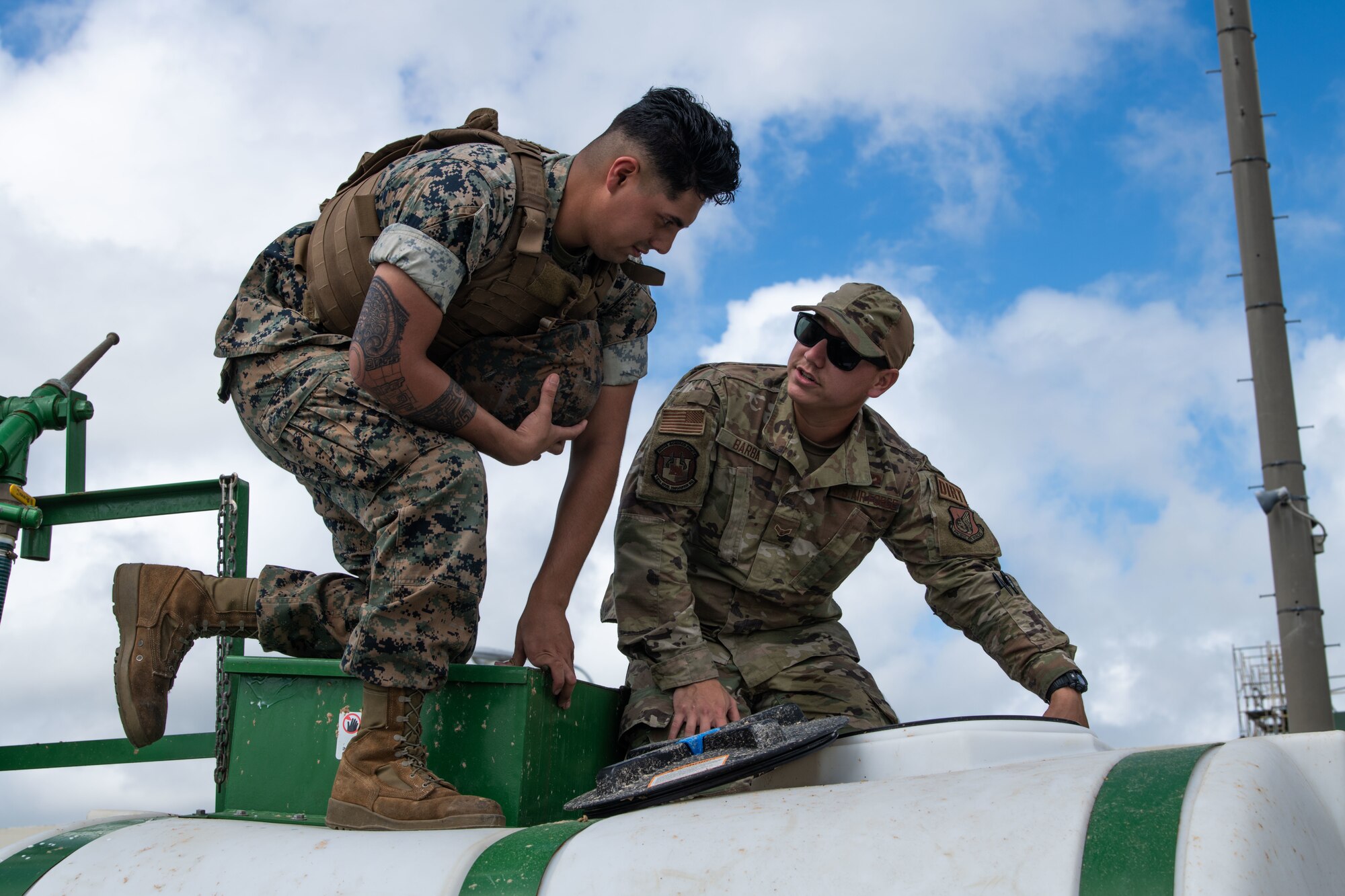 A Marine and Airman inspect equipment.