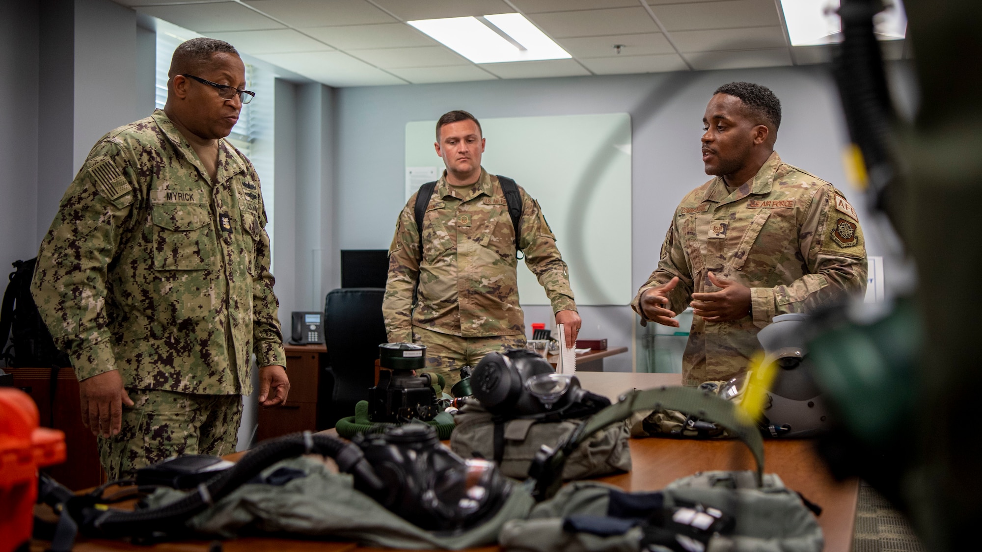 U.S. Navy Fleet Master Chief Donald Myrick, U.S. Transportation Command senior enlisted leader, discusses innovations in flight equipment with Tech. Sgt. Christian Cummings, a member assigned to the 6th Operations Support Squadron aircrew flight equipment section, during a tour at MacDill Air Force Base, Florida, April 29, 2022. Myrick visited AFE to learn more about the new M69 Aircrew Eye and Respiratory Protection System. (U.S. Air Force photo by Airman 1st Class Lauren Cobin)