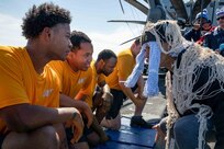 Sailors, assigned to the San Antonio-class amphibious transport dock ship USS Arlington (LPD 24), are welcomed into the “Order of the Blue Nose” during an Arctic Circle ceremony on Arlington’s flight deck, April 22, 2022.